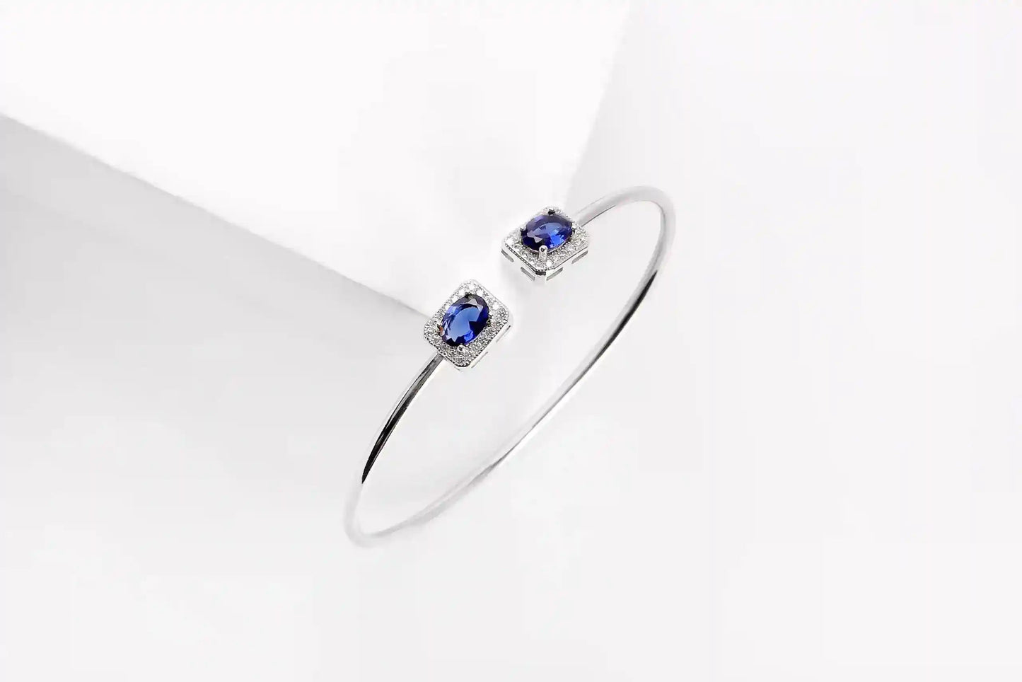 Viorette open bangle in 925 sterling silver with glowing blue zircon stones