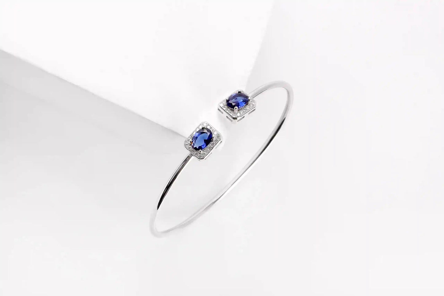 Viorette open bangle in 925 sterling silver with glowing blue zircon stones