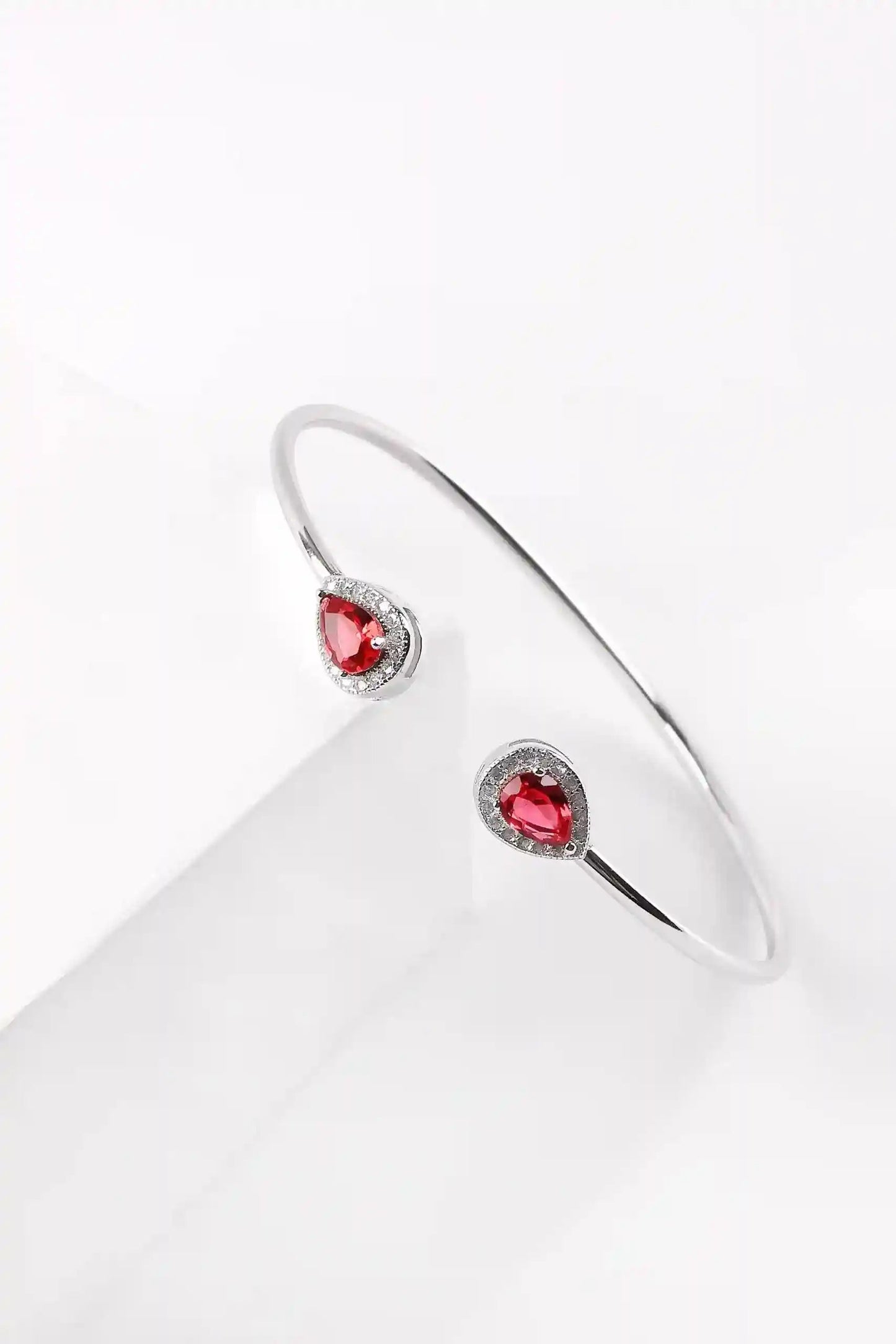 Viorette teardrop open bangle in 925 sterling silver with a red ruby-colored teardrop stone